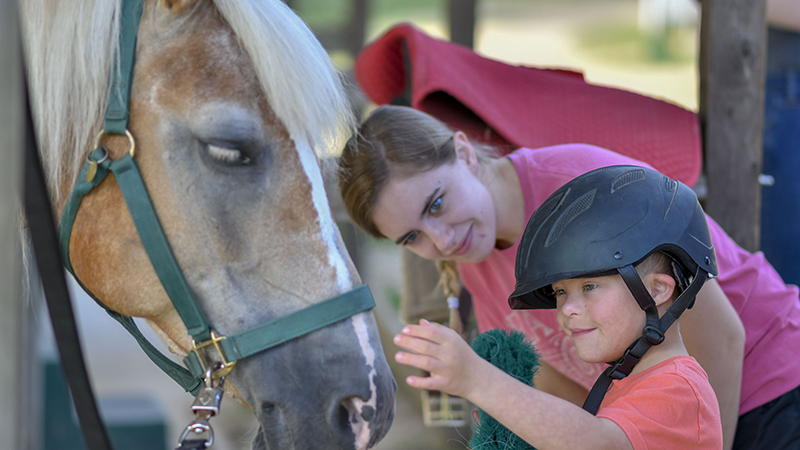 Camper and grad student with horse at Horsepower Summer Camp