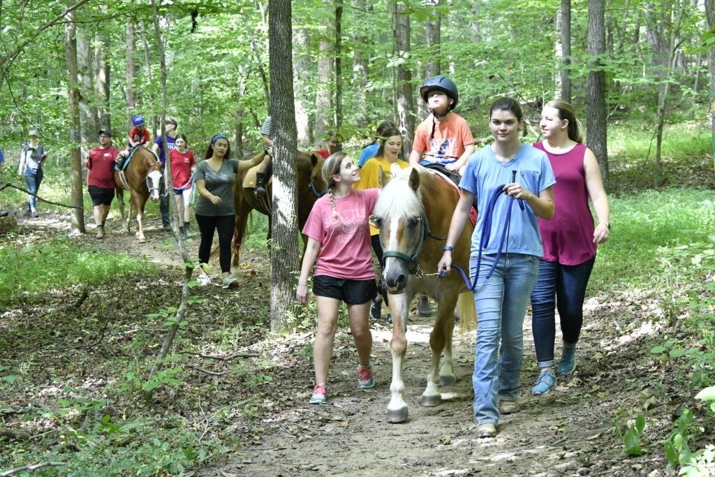 Instructors guiding campers on a trail ride